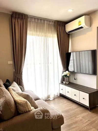 Cozy living room with modern decor, featuring a wall-mounted TV and air conditioning.