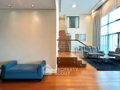 Luxurious modern living room with elegant staircase and plush seating