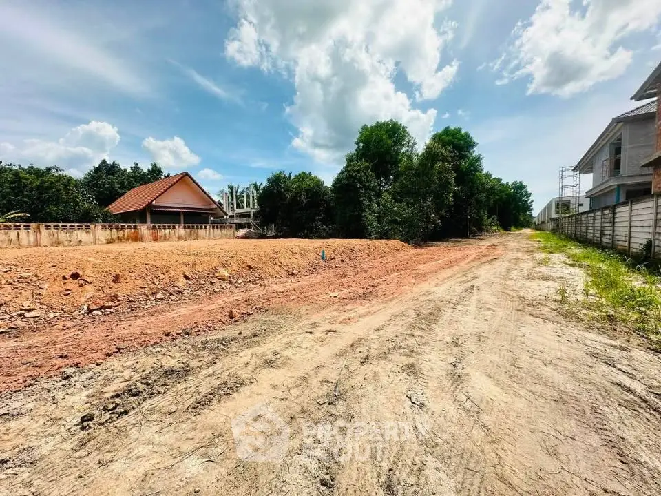 Expansive land plot with clear skies, ideal for development in a serene neighborhood.