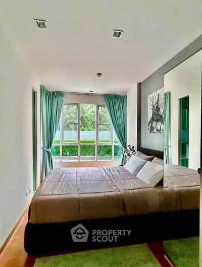 Bright and cozy bedroom with large window and green view, perfect for relaxation.