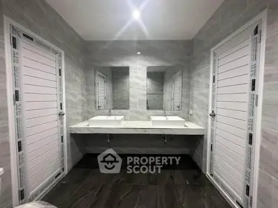 Modern bathroom with dual sinks and sleek gray tile design