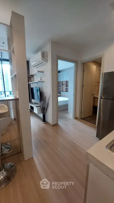 Modern apartment interior with open kitchen and view into bedroom