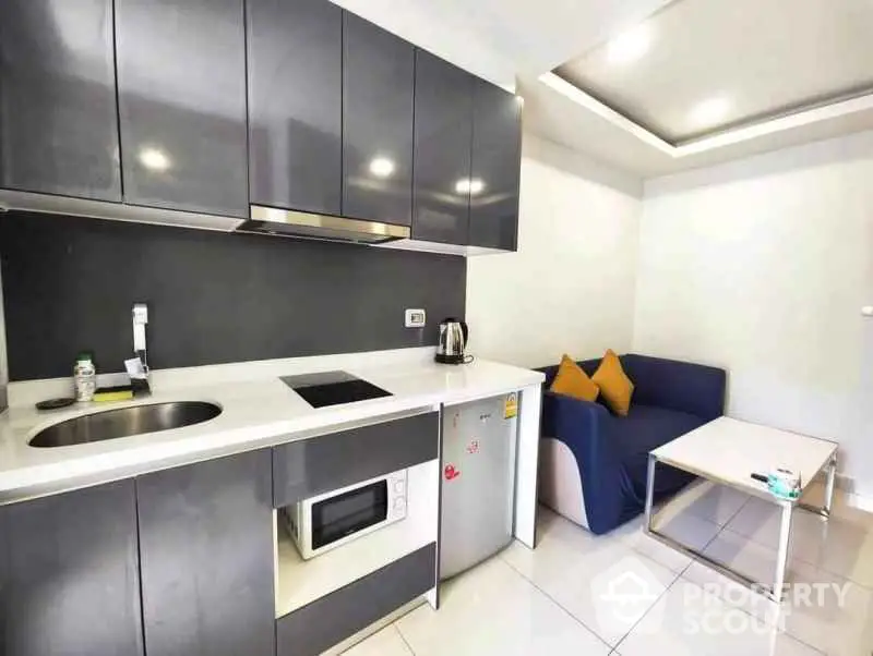 Modern compact kitchen with sleek cabinetry and cozy seating area