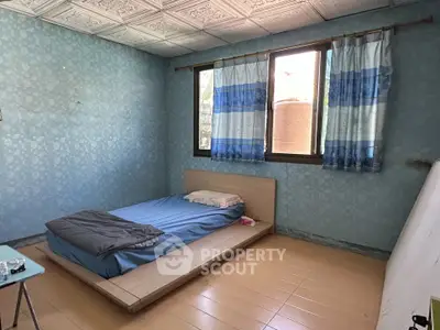 Cozy bedroom with minimalist design and large windows for natural light.