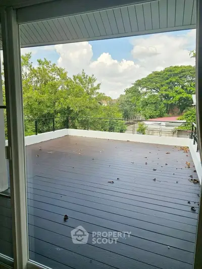 Spacious balcony with scenic view of lush greenery and clear skies.