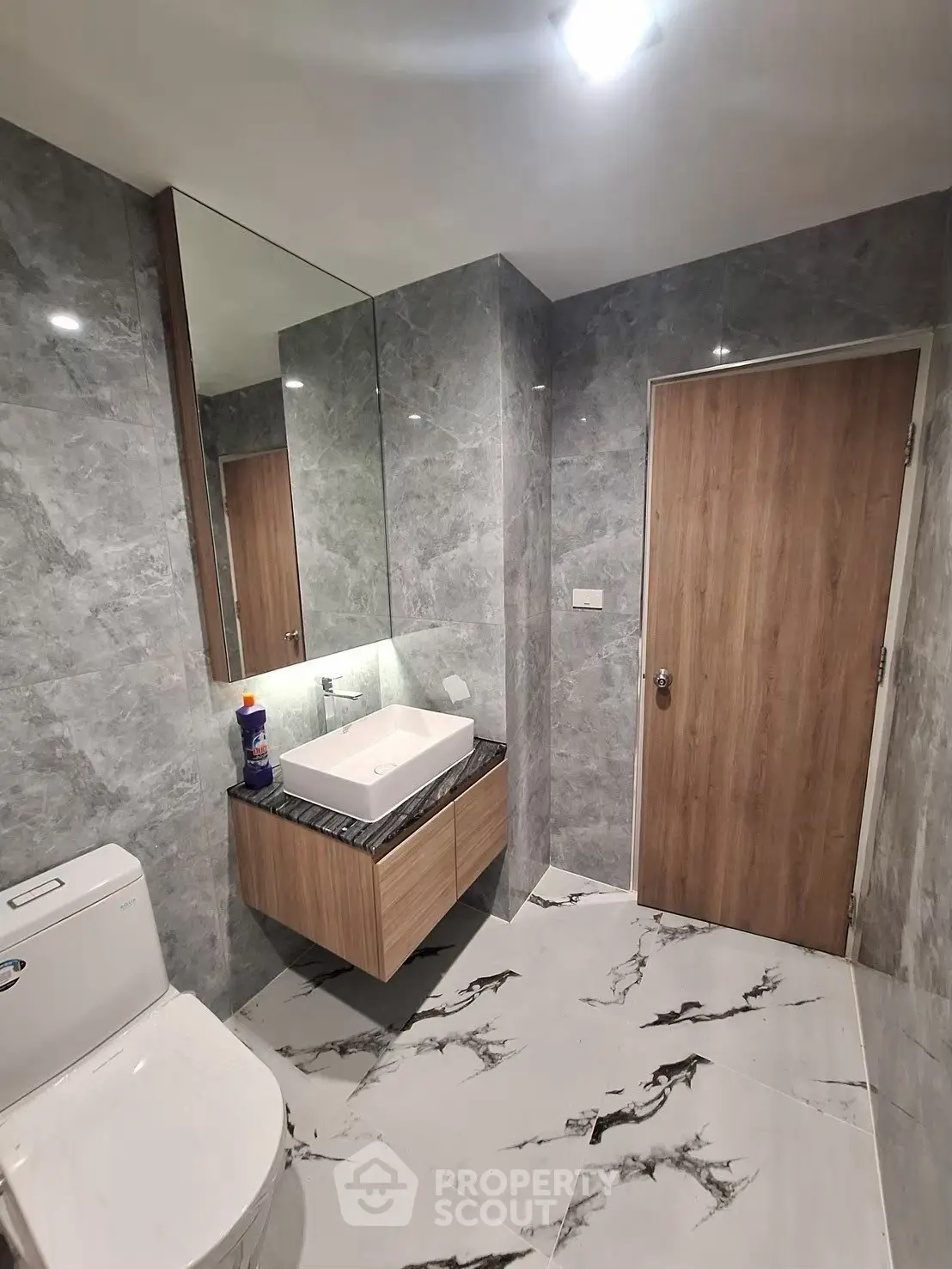Modern bathroom with marble tiles and sleek wooden cabinetry