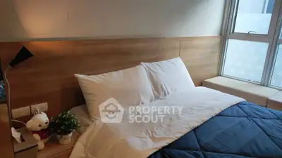 Cozy bedroom with plush bedding and natural light from large window