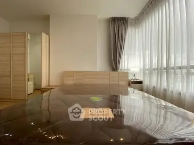 Spacious bedroom with large windows and modern furniture, perfect for relaxation.