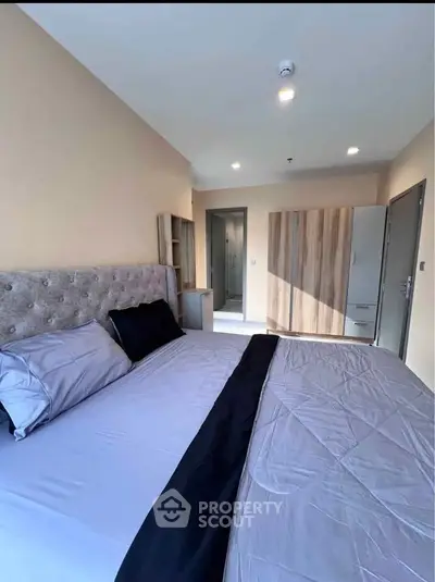 Spacious modern bedroom with elegant decor and ample natural light