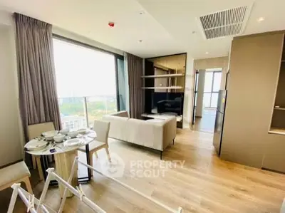 Modern living room with large windows and stylish furniture in a bright apartment.