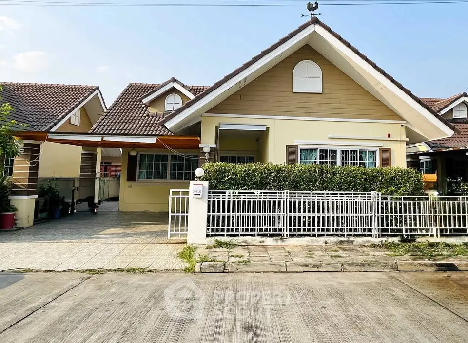 Charming suburban house with a gabled roof and fenced front yard, perfect for family living.
