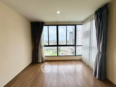 Spacious empty room with large windows offering stunning city views, perfect for customization.