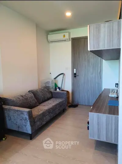 Modern living space with sleek furnishings and a cozy atmosphere, featuring an elegant sofa and a stylish wood-themed kitchenette.