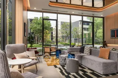 Modern living room with large windows and stylish furniture in a contemporary building.