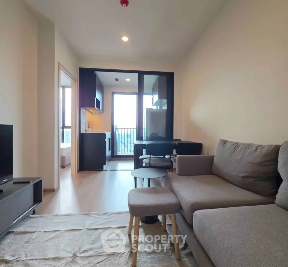 Modern living room with cozy sofa and open kitchen layout in a stylish apartment.