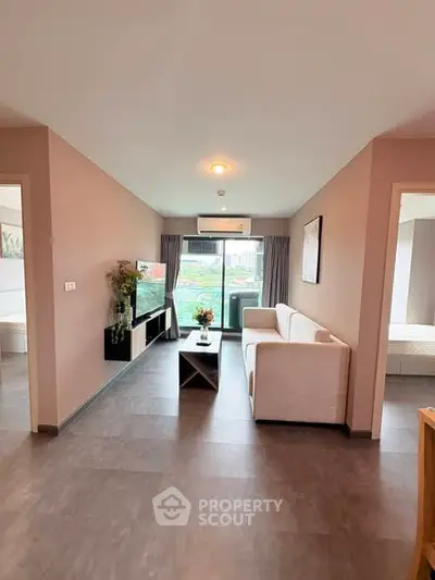 Modern living room with sleek design and large window offering natural light and city view.