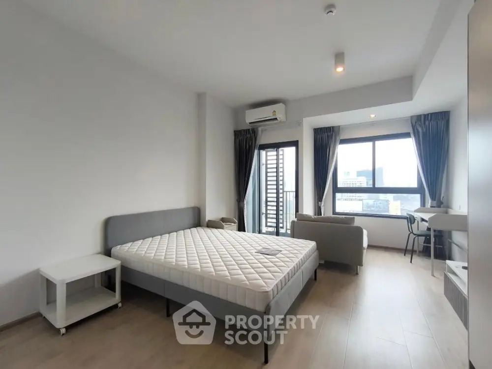 Spacious modern bedroom with city view and minimalist decor