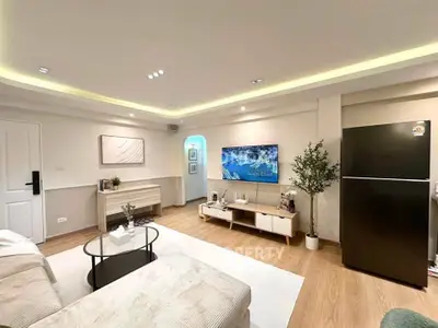 Modern living room with sleek design, featuring a cozy sofa, stylish TV unit, and elegant lighting.
