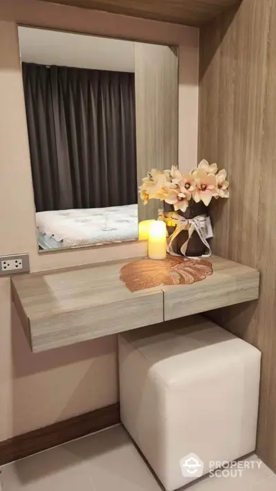 Elegant bedroom vanity with mirror and floral decor in modern apartment