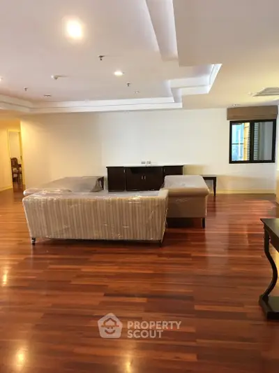 Spacious living room with elegant wooden flooring and modern furniture
