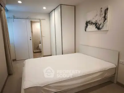 Modern minimalist bedroom with sliding door and abstract art
