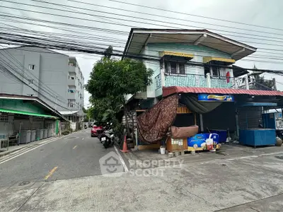 Charming corner building with balcony on a quiet street, ideal for residential or commercial use.