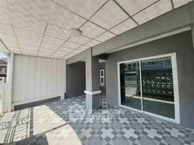 Spacious covered patio with modern tile flooring and sliding glass doors