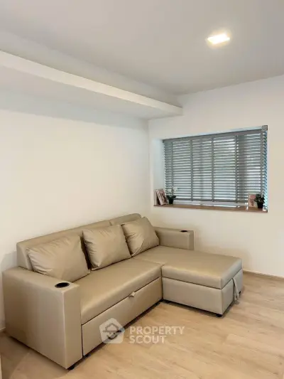 Modern living room with sleek beige sofa and stylish window blinds