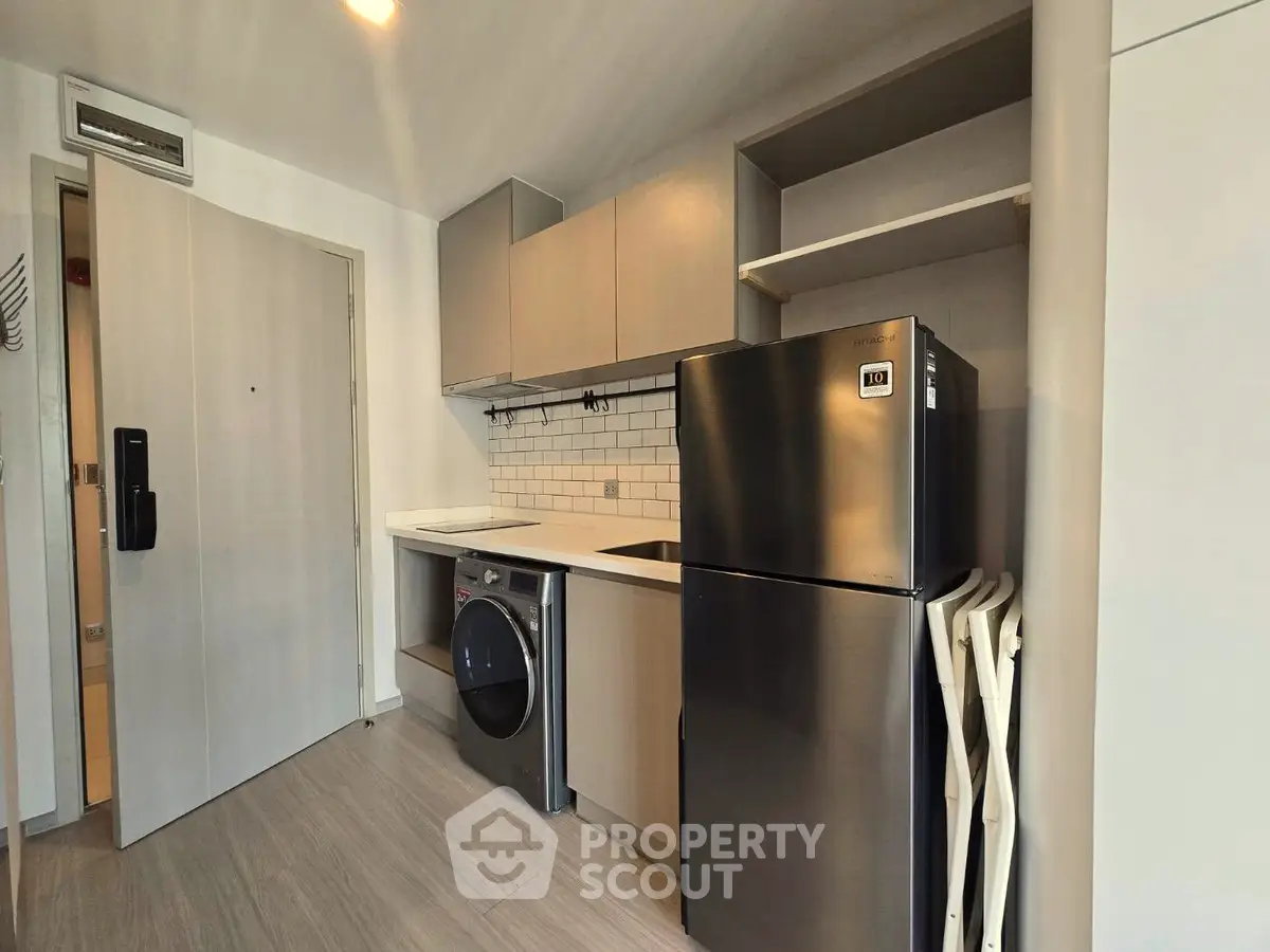 Modern kitchen with sleek appliances and stylish cabinetry in a compact layout.