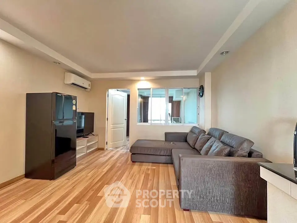Spacious living room with modern gray sofa and sleek wooden flooring