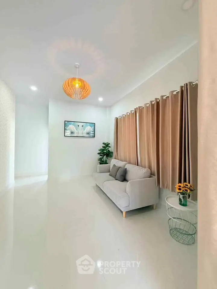 Modern living room with elegant decor, featuring a cozy sofa, stylish lighting, and tasteful artwork.