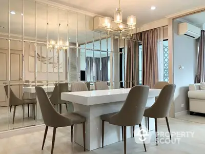 Elegant dining area with modern chandelier and mirrored wall in luxury apartment