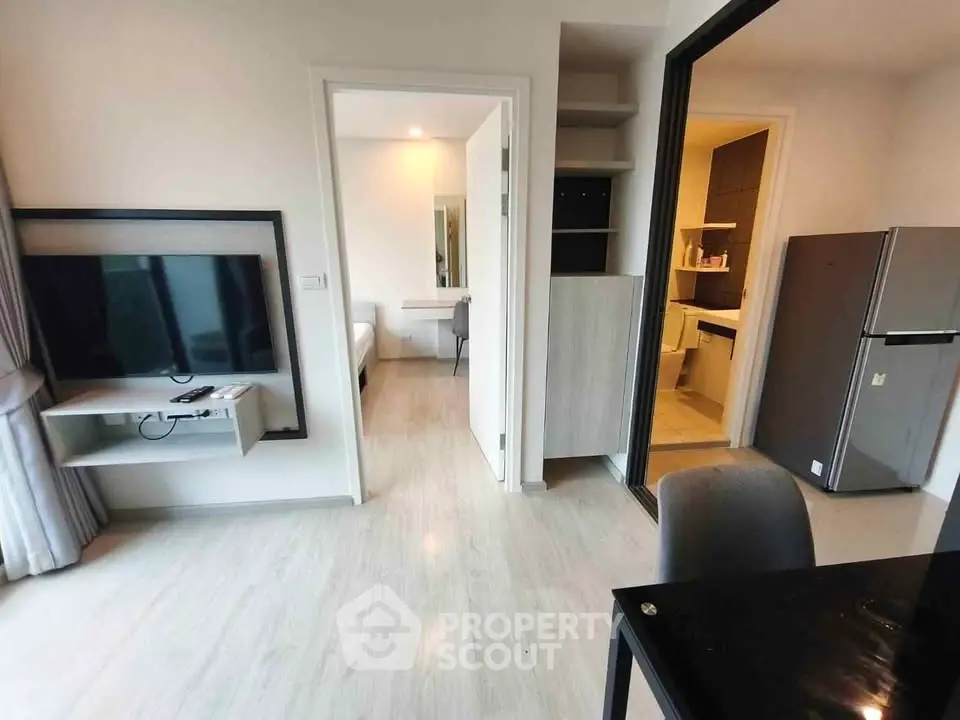 Modern apartment interior with open layout, featuring a sleek kitchen and cozy living area.