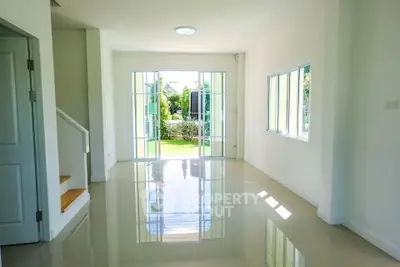 Spacious and bright living room with garden view and glossy floors