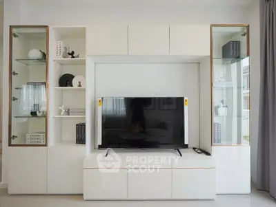 Modern living room with sleek white entertainment center and flat-screen TV, perfect for stylish home decor.