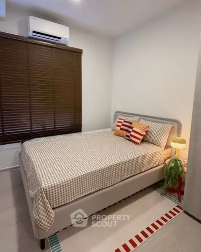 Cozy bedroom with stylish decor and air conditioning, perfect for relaxation.