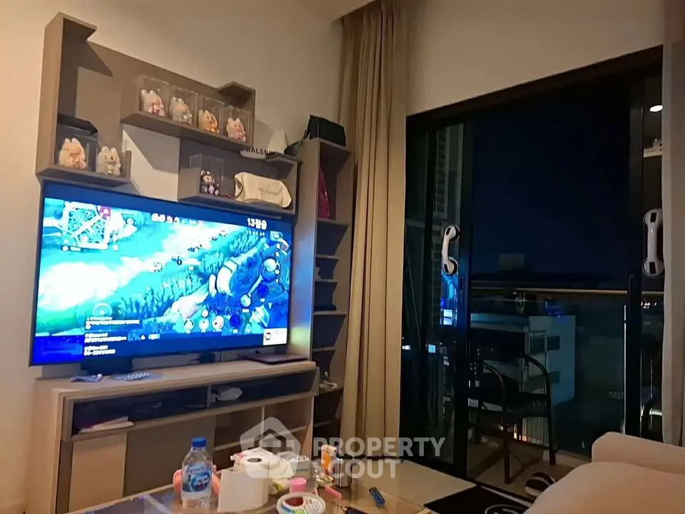 Cozy living room with entertainment setup and balcony view, perfect for relaxation and leisure.