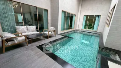 Luxurious indoor pool area with elegant seating and large windows