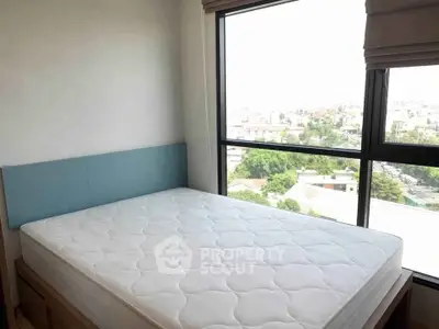 Bright bedroom with large window offering stunning city views and natural light.
