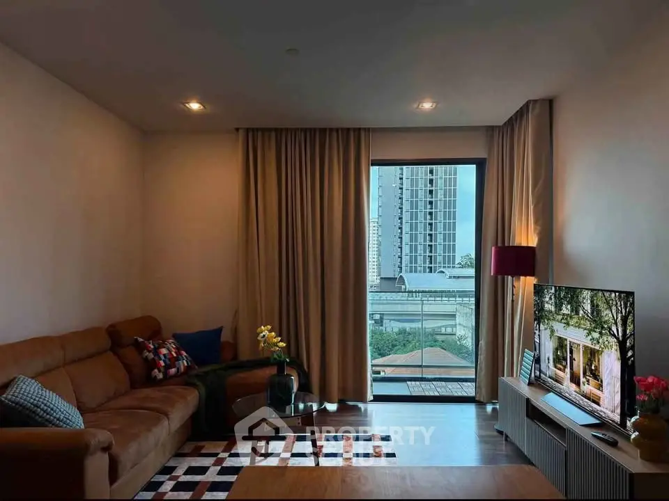 Stylish living room with modern decor and city view from large window.