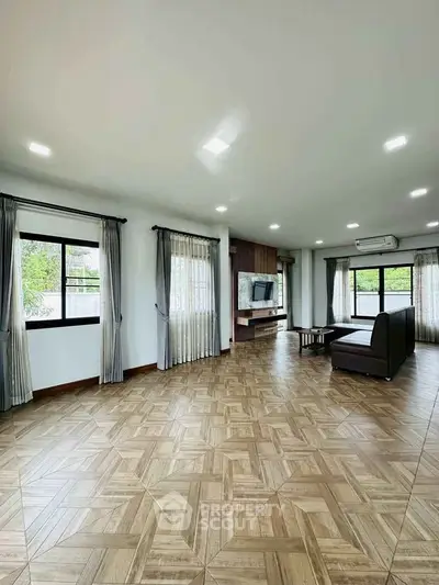 Spacious living room with modern decor and large windows offering natural light.