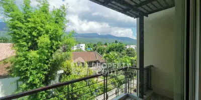 Charming balcony with stunning mountain view and lush greenery, perfect for relaxation.