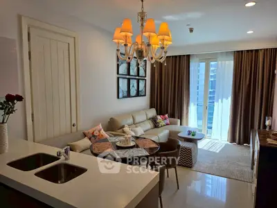Modern living room with elegant chandelier and cozy seating area, featuring a large window with city view.