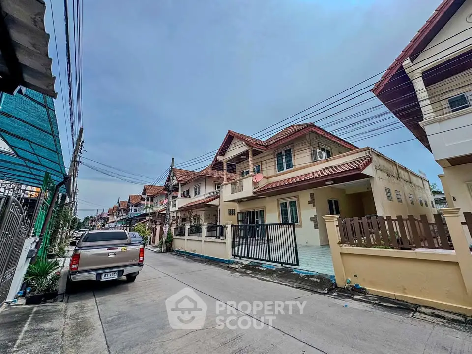 Charming suburban street with modern townhouses and parked vehicle, ideal for family living.