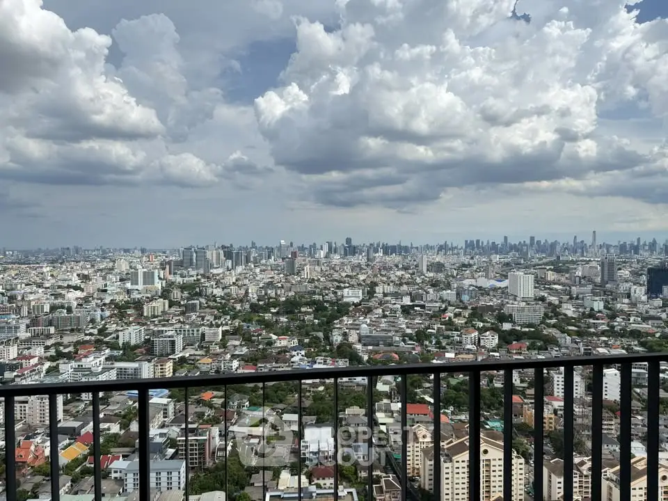 Stunning cityscape view from a high-rise balcony, showcasing urban skyline under dramatic clouds.