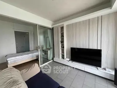 Modern living room with sleek TV setup and cozy bedroom view