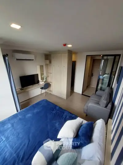 Modern bedroom with stylish decor and cozy seating area, perfect for relaxation.