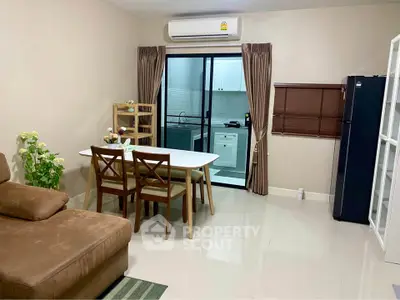 Cozy living room with dining area and modern kitchen in open layout apartment.