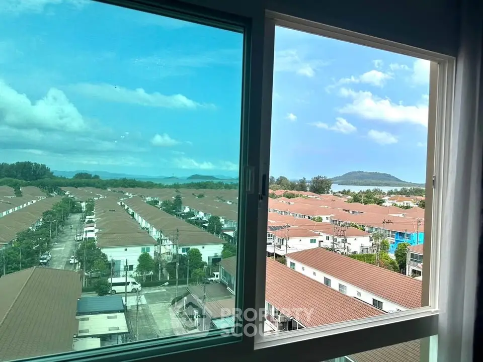 Stunning view from a high-rise window overlooking a suburban neighborhood and distant mountains.