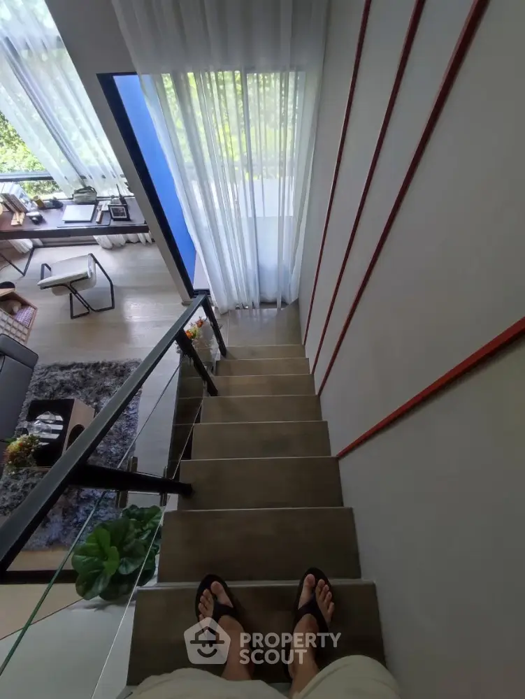 Modern duplex interior with stylish staircase and cozy living room view